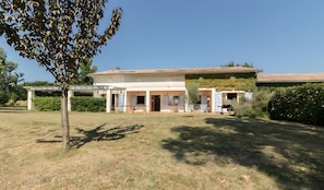 A two-story house with a covered patio, a garage, and a garden.