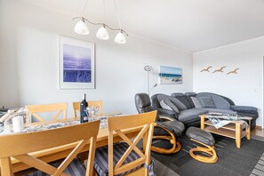 Un salon moderne comprenant un coin repas, un canapé et une table basse.