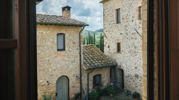 A stone building with a tiled roof, arched doorways, and windows. - La Loggetta, a refuge in the heart of authentic Tuscany (colle di val d'elsa)