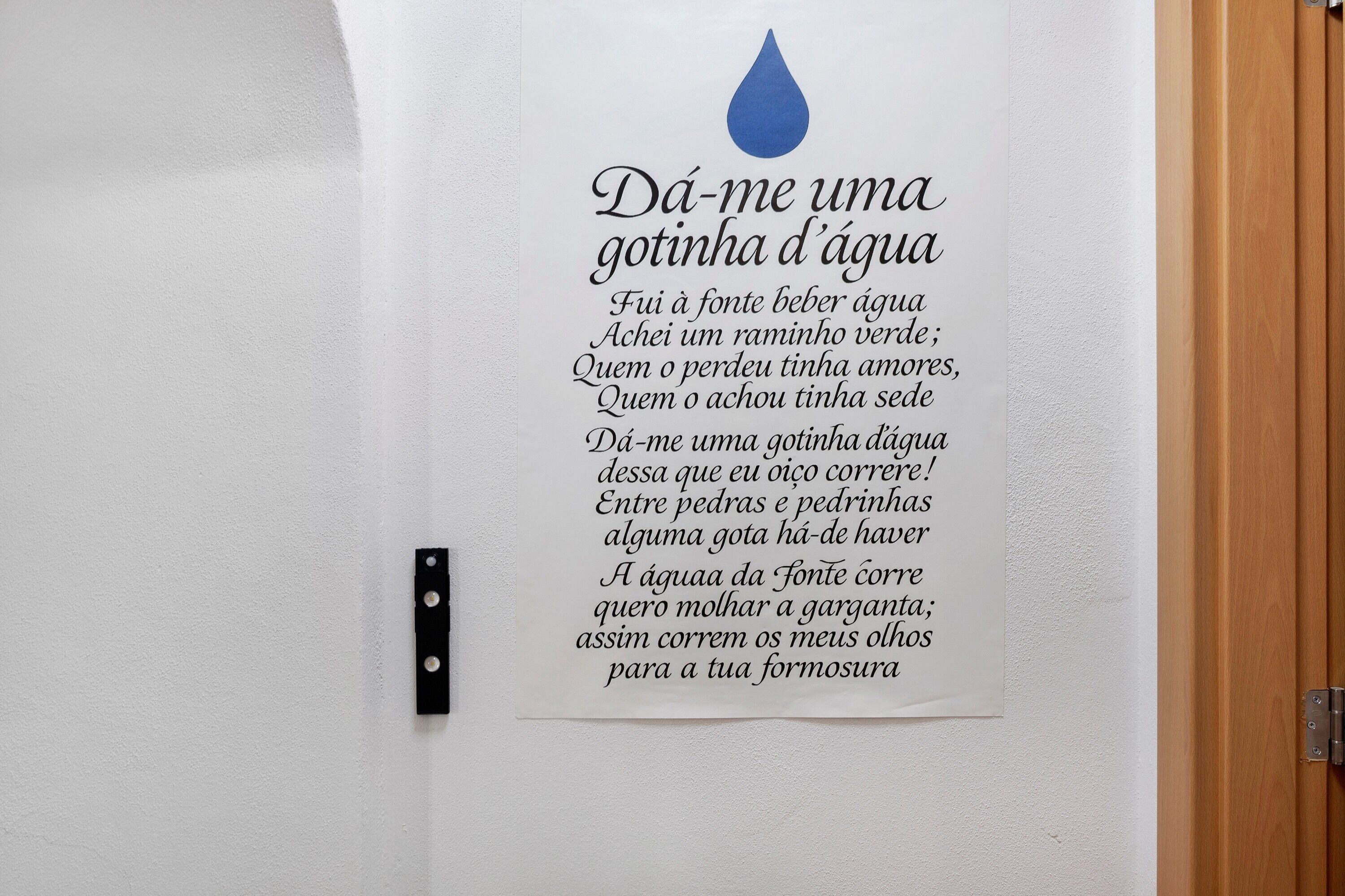 Una pared con un gráfico de una gota de agua y un poema en portugués.