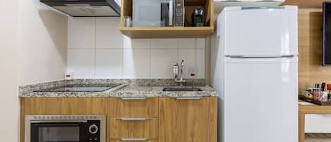 Una cocina equipada con microondas, cafetera y refrigerador.