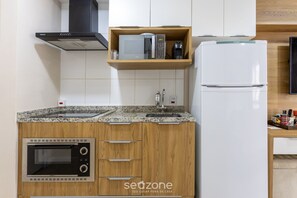 A kitchen with a built-in microwave, a coffee maker, and a refrigerator. - Studio With Balcony 500m From the Metro - Mop0103 (São Paulo)
