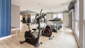 A gym with cardio machines, a wooden floor, and large windows. - Studio With Balcony 500m From the Metro - Mop0103 (São Paulo)