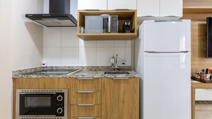 A kitchen with a built-in microwave, a coffee maker, and a refrigerator. - Studio With Balcony 500m From the Metro - Mop0103 (São Paulo)
