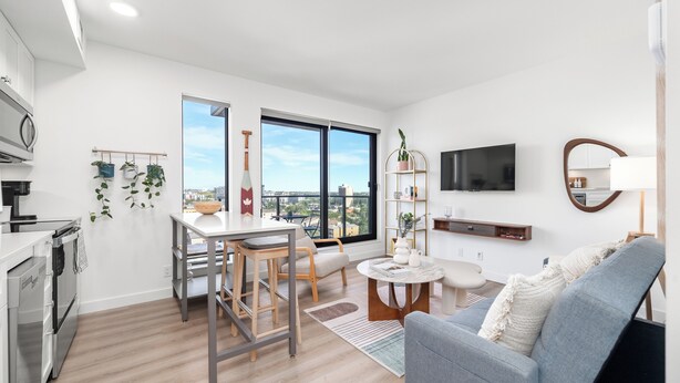 A modern apartment with a kitchen, dining area, and living room. - Stylish Condo W/ Stunning views & Short Walk DT (Calgary)
