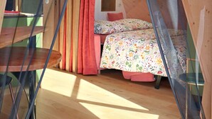 Une pièce circulaire et accueillante, avec un lit, une petite table et une fenêtre.