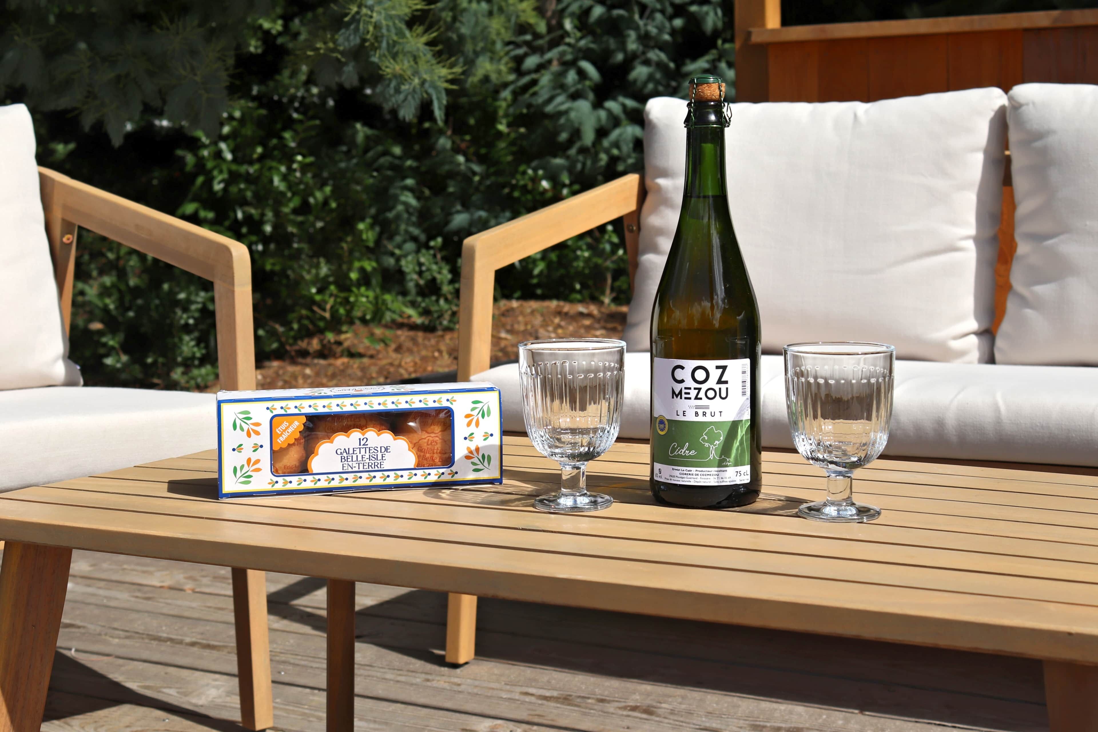 A wooden table with a bottle of Coz Mezou wine, two glasses, and a box of Galette des Rois.