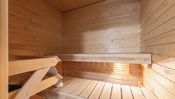 Un intérieur en bois avec un plafond en pente et une fenêtre laissant entrer la lumière naturelle.