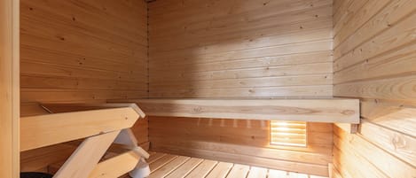 Een houten interieur met een schuine kap en een raam dat natuurlijk licht binnenlaat.