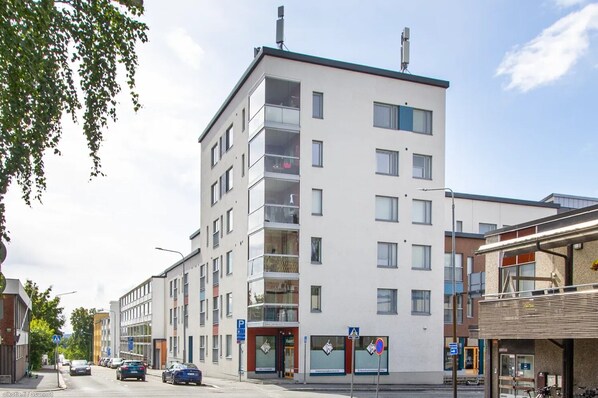 A multi-story building with a modern architectural design, featuring balconies and large windows. - Stylish Nordic 2BR Apartment with Sauna (Kuopio)