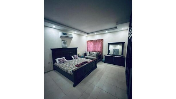 Un dormitorio con cama, cómoda y espejo.