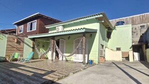 A house with a porch, a hammock, and a water tank.
