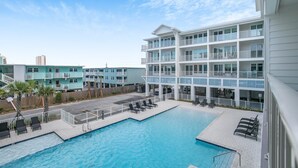 Un hôtel doté d’une piscine, de plusieurs balcons et offrant une vue sur les bâtiments environnants.