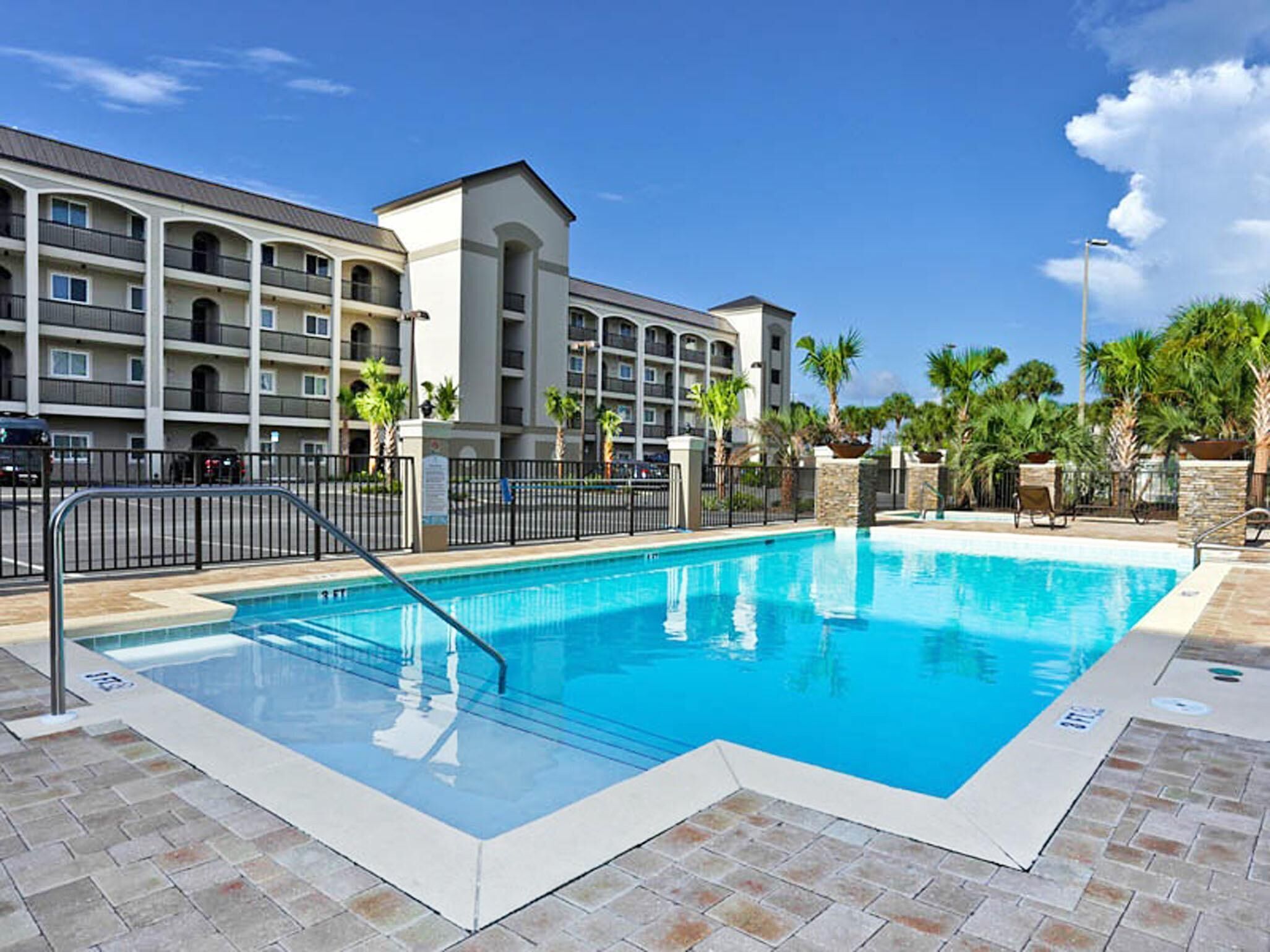 Une piscine à l’eau d’un bleu limpide, entourée d’une terrasse carrelée.