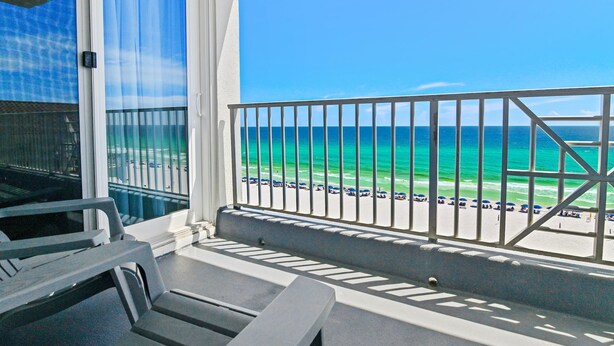 Een balkon met uitzicht op het strand en de oceaan.