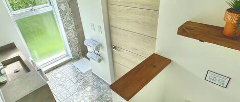 Un baño con baldosas estampadas, un inodoro, un lavamanos y un perchero para toallas.