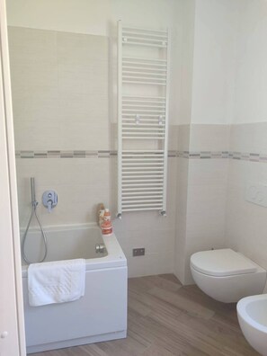 Een douche, een haardroger, een bidet, handdoeken