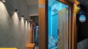 A hotel entrance with a wooden door, a blue patterned wall, and a sign indicating room number 502. - PS Pristine Beach Sea View Apartment (AP)