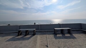 A rooftop terrace with concrete benches and a view of the sea. - PS Pristine Beach Sea View Apartment (AP)