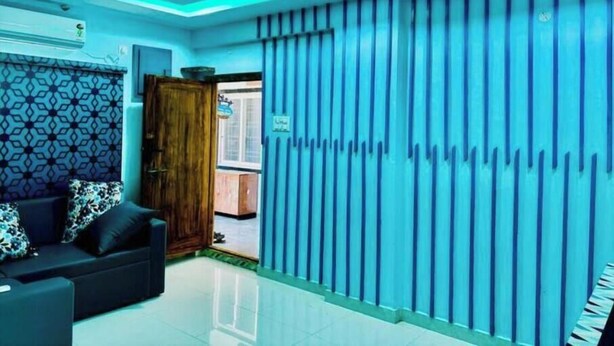 A modern hotel lobby with a ceiling fan, a patterned wall, a sofa with cushions, and a vertical striped wall. - PS Pristine Beach Sea View Apartment (AP)