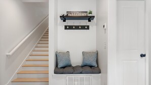 A staircase with a bench seat, a wall-mounted sign, and a door.