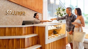 Un espace d’accueil avec un comptoir en bois, un mur en briques et une enseigne sur laquelle on peut lire « SPARITUA ».