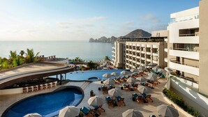 A resort with a pool area, lounge chairs, and a view of the sea. - Ocean Views & Private Hot Tub. 2-Bedroom Beachfront Resort in Los Cabo's (Cabo San Lucas)
