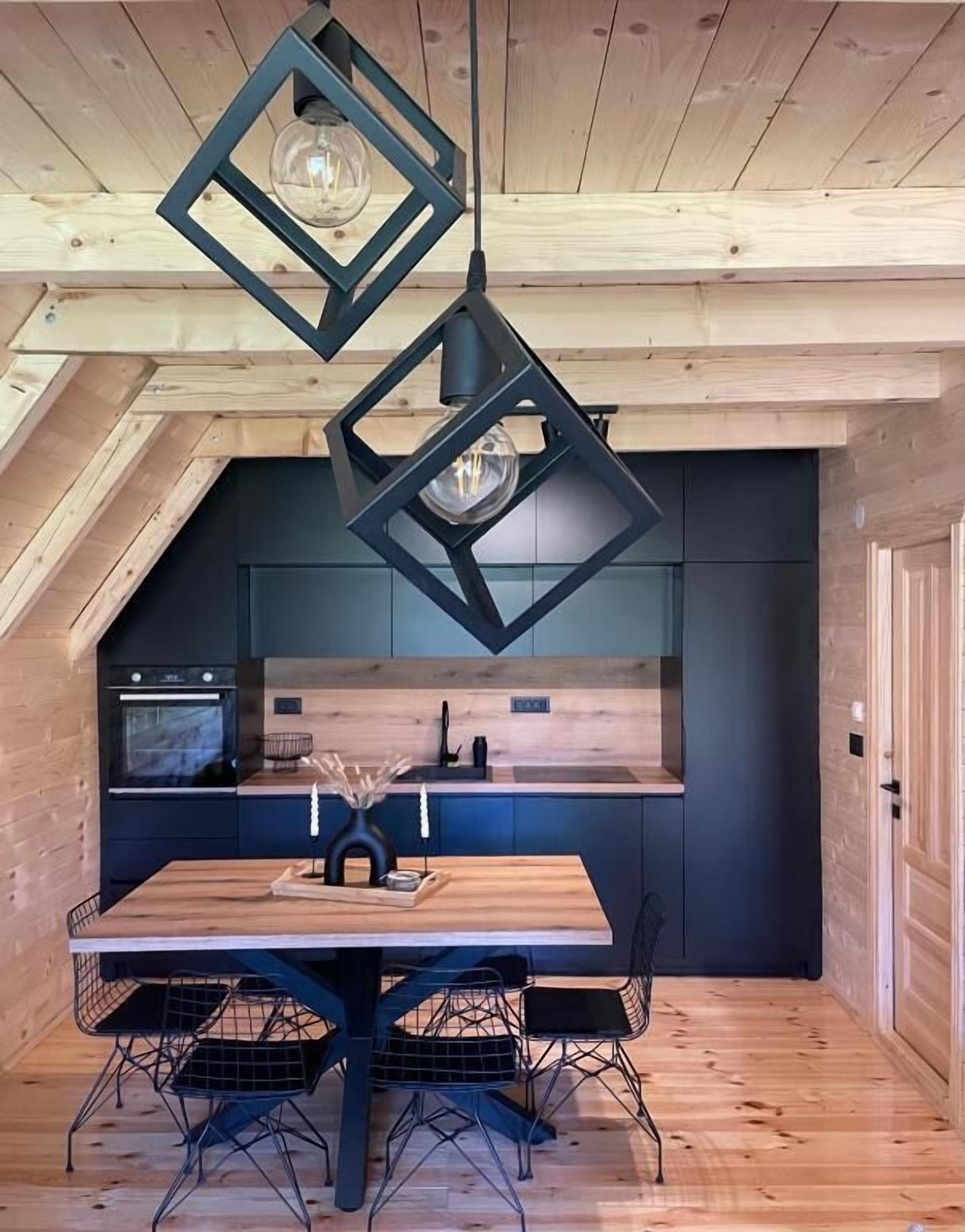 A modern kitchen with a wooden ceiling, black cabinets, and a central island.