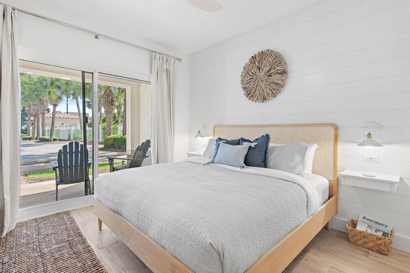 Un dormitorio con una cama grande, una mesita de noche, una decoración en la pared y vistas al exterior.