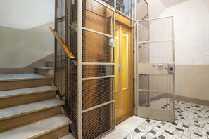 A staircase with metal railings and a tiled floor. - Luxury Bridge Apartment (Florence)