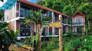 A two-story building with a red roof, large windows, and balconies. - An Peaceful Homestay (Hai Phong)