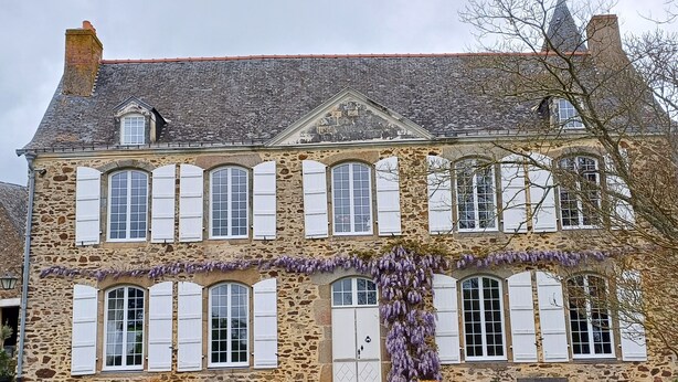 A stone building with multiple windows and a central entrance.