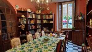A dining area with a table set for four, surrounded by bookshelves filled with books.