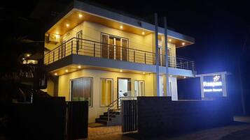 A two-story building with a balcony, a staircase, and a sign indicating it is a resort.