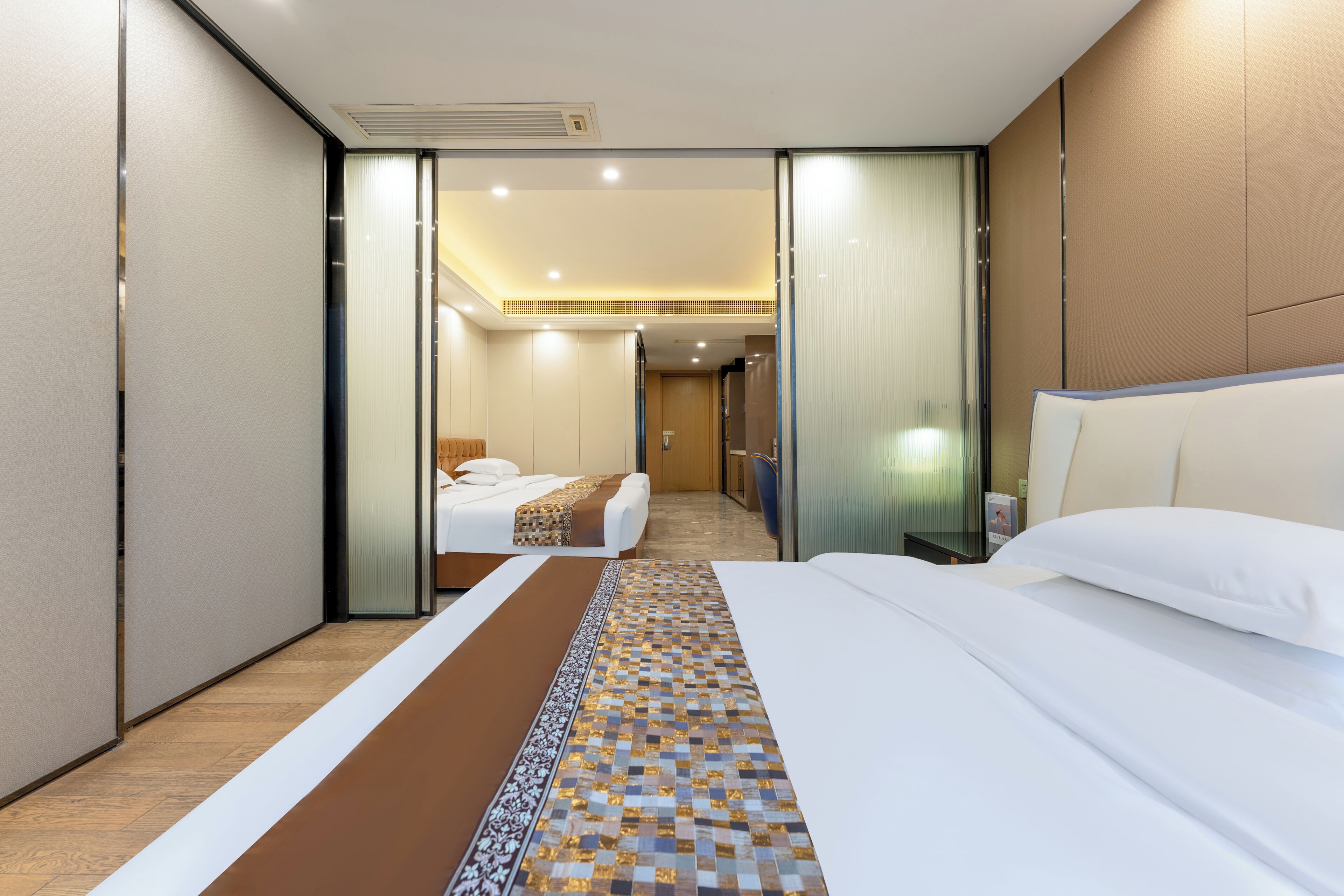 Een hotelkamer met een groot bed, een nachtkastje en uitzicht op de hal.