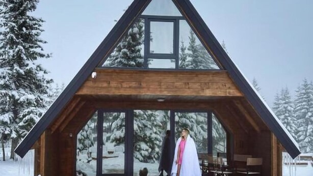 A wooden cabin with a triangular roof and large windows, surrounded by snow-covered trees. - Mountain Home Durmitor 1 (Uskoci)