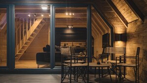 A cozy attic room with a wooden staircase, a dining area with chairs and a table, and a large window. - Mountain Home Durmitor 1 (Uskoci)