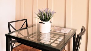 A dining table with four chairs, a glass top, and a potted plant.