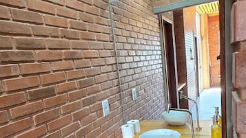 Eenvoudige chalet | Badkamer | Een douche, een haardroger, handdoeken, toiletpapier