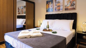 Une chambre d’hôtel avec un grand lit, une table de chevet avec une bouteille et des verres, et un miroir.