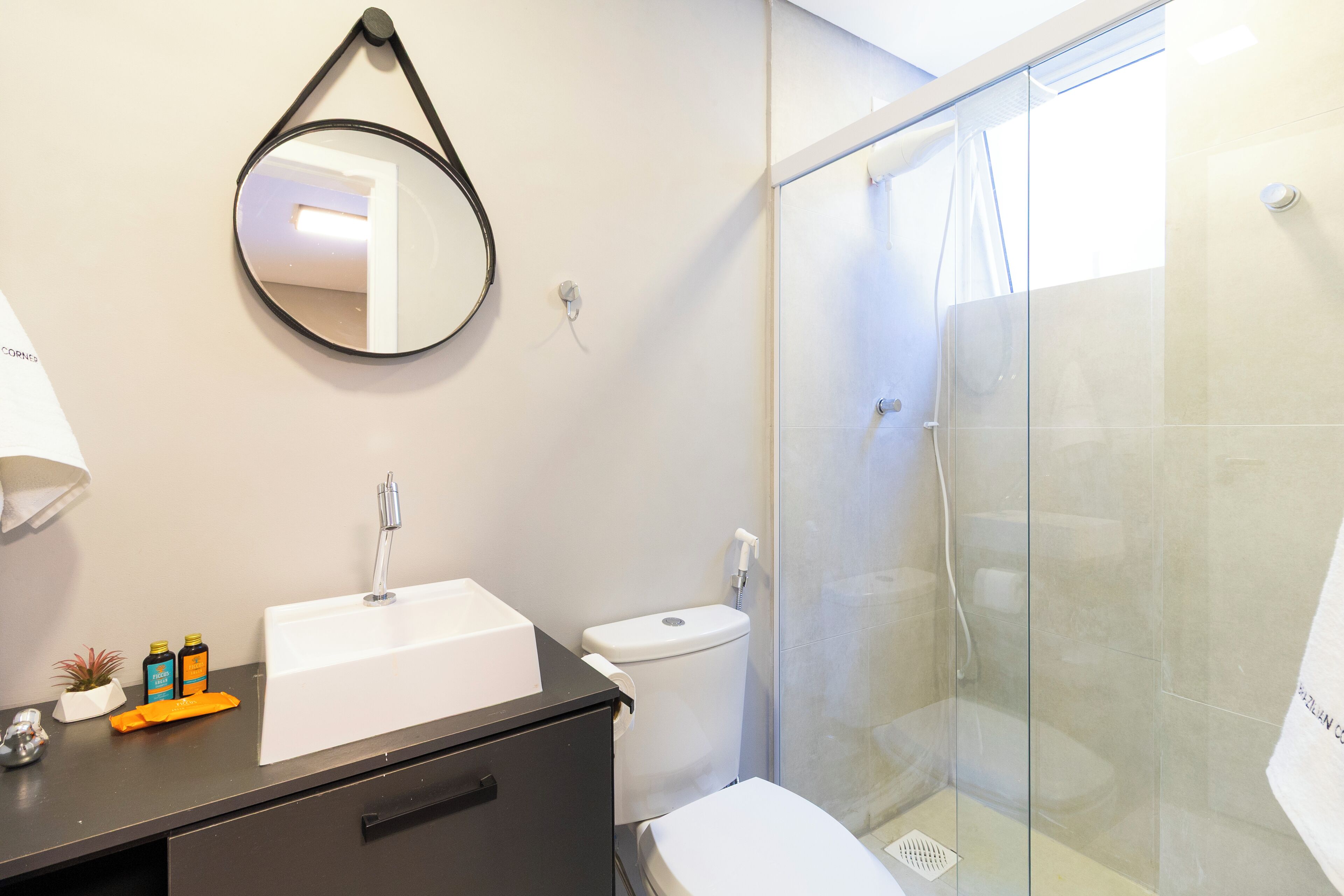 A bathroom with a white sink, a toilet, and a glass-enclosed shower.