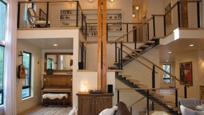 A spacious interior with a grand staircase, a piano, and a cozy seating area. - Beautiful Mountain Modern Home with well equipped kitchen. Perfect for families. (Ketchum)