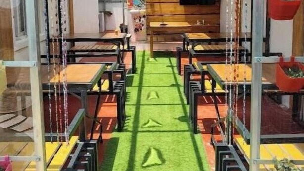 A children's play area with tables and chairs, a green carpet, and hanging decorations. - Diamond hill view cottage (Ooty)