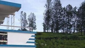 Un edificio moderno con techo plano, un espacio exterior cubierto y una escalera que conduce a un nivel inferior.