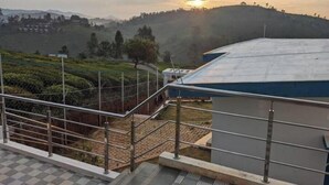 Una terraza con vistas a un paisaje montañoso y un atardecer.