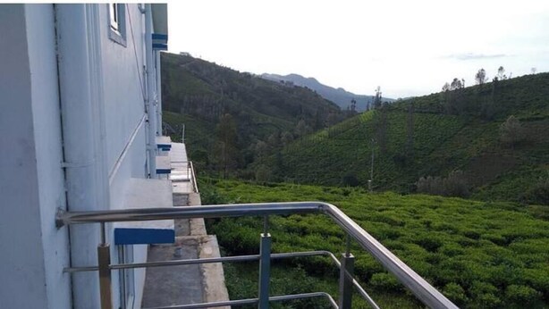 A staircase leading to a building with a view of a lush green hillside. - Kathiresan's Diamond hill view cottage (Ooty)
