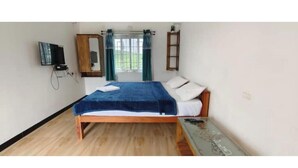 A bedroom with a wooden bed, a television mounted on the wall, a wardrobe, and a window with curtains. - Kathiresan's Diamond hill view cottage (Ooty)