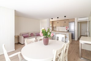 A modern kitchen with white cabinets, a central island, and pendant lighting.