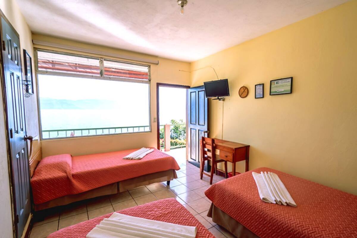 A room with two beds, a desk, and a television.
