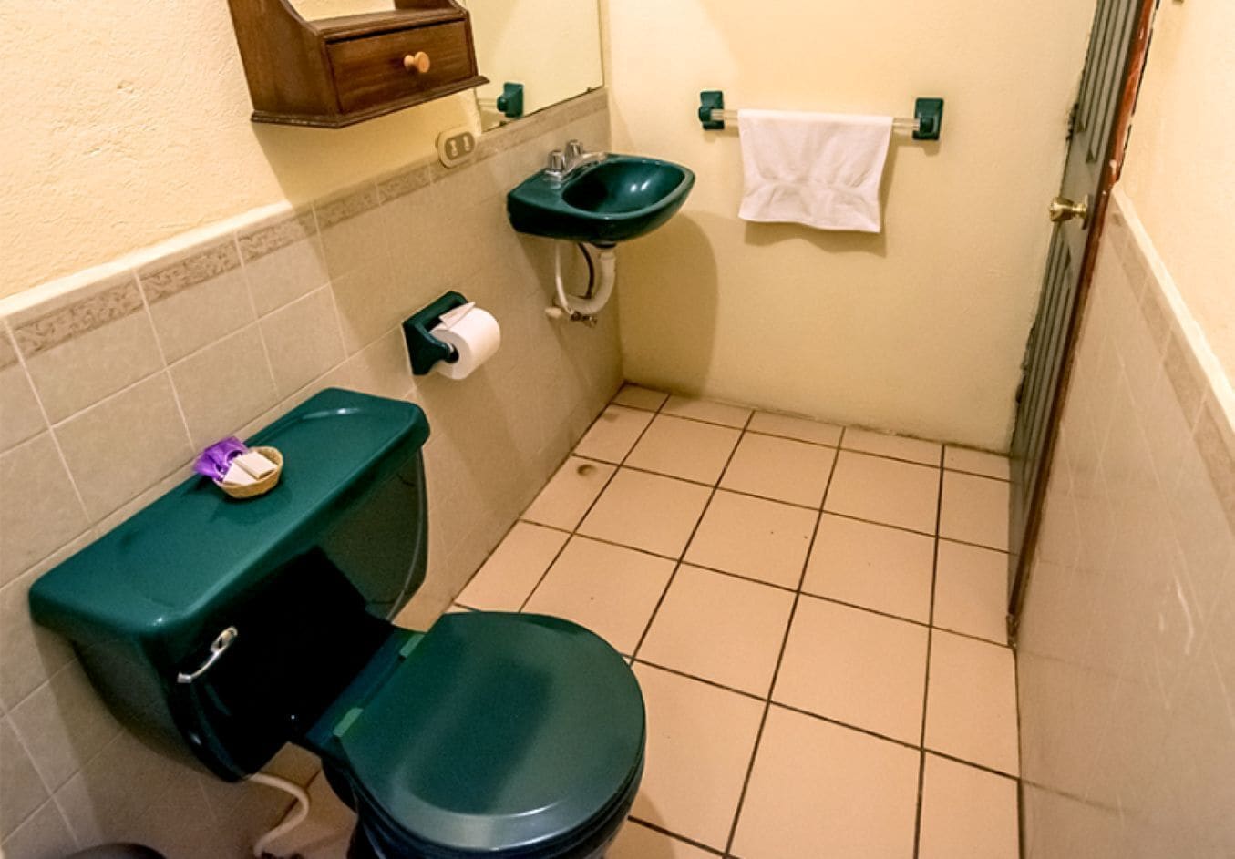 Une petite salle de bain avec des toilettes, un lavabo et une serviette accrochée au mur.